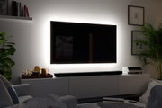 Téléviseur noir avec rétroéclairage LED blanc sur mur dans un salon moderne