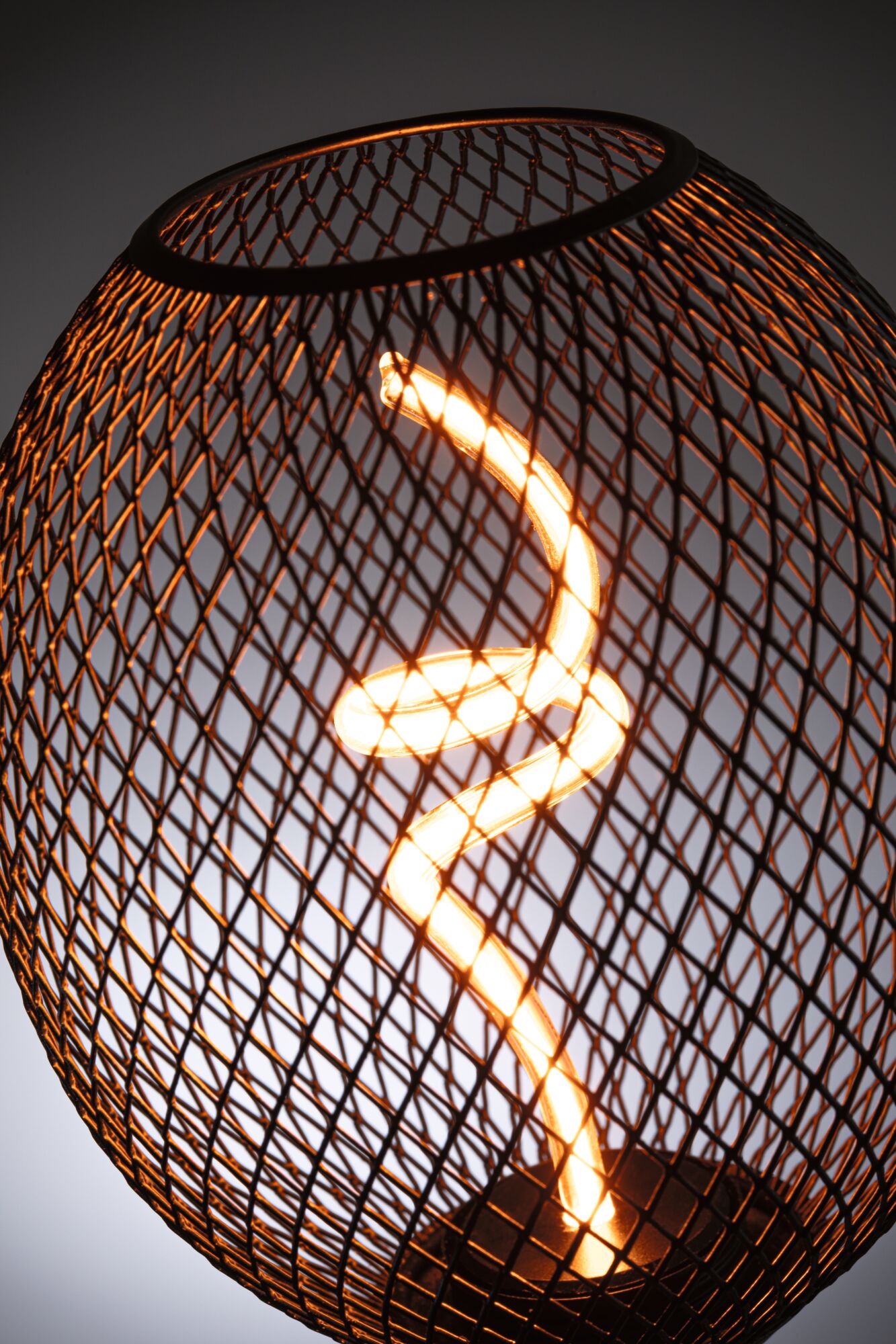 Moderne Tischlampe mit schwarzem Metallgitter und spiralförmiger LED-Leuchte für stimmungsvolle Beleuchtung
