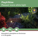 Outdoor spotlights with warm white light on gravel and plants creating atmospheric garden and terrace lighting