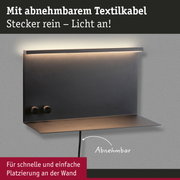 Schwarze Wandlampe aus Metall mit abnehmbarem Textilkabel und warmweißem LED-Licht für einfache Montage