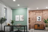 Modernes Büro mit grün gestrichener Wand, schwarzem Tisch, grauem Stuhl und Ziegelsteinwand mit Sideboard.