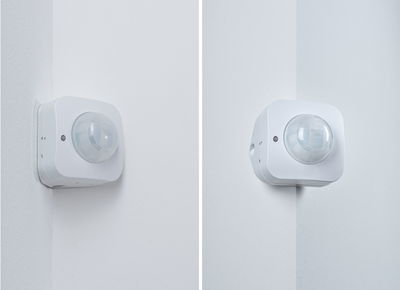 Weißer Bewegungsmelder aus Kunststoff an Innenwandecke montiert für Lichtsteuerung