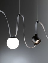 Moderne pendel med hvid glasglobus og sort metalspot på gråt tekstilkabel