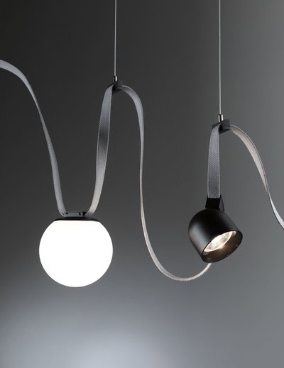 Moderne pendel med hvid glasglobus og sort metalspot på gråt tekstilkabel