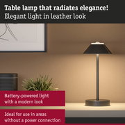 Elegant black leather-look table lamp with modern design, battery-powered for versatile use