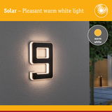 Solar-powered house number 9 with warm white light on grey wall for outdoor lighting