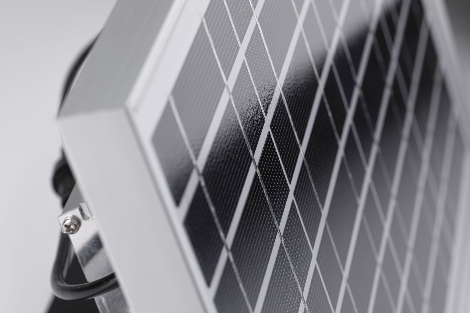 Nærbillede af sølvfarvet aluminiumsramme med sorte solceller til bæredygtig energi.