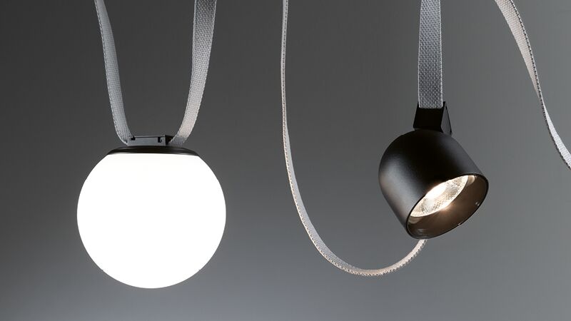 Moderne hanglamp met witte bolvormige kap en zwarte spot aan grijze textielkabel voor woonverlichting