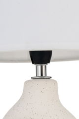 Close-up van witte keramische lamp met zwarte spikkels en chromen metalen onderdeel voor binnenverlichting