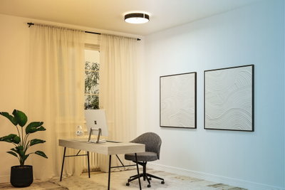 Modern home office with light wood desk, grey office chair, and decorative wall art featuring wave patterns.