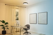 Bureau moderne avec bureau en bois clair, chaise grise et tableaux muraux décoratifs à motifs ondulés.
