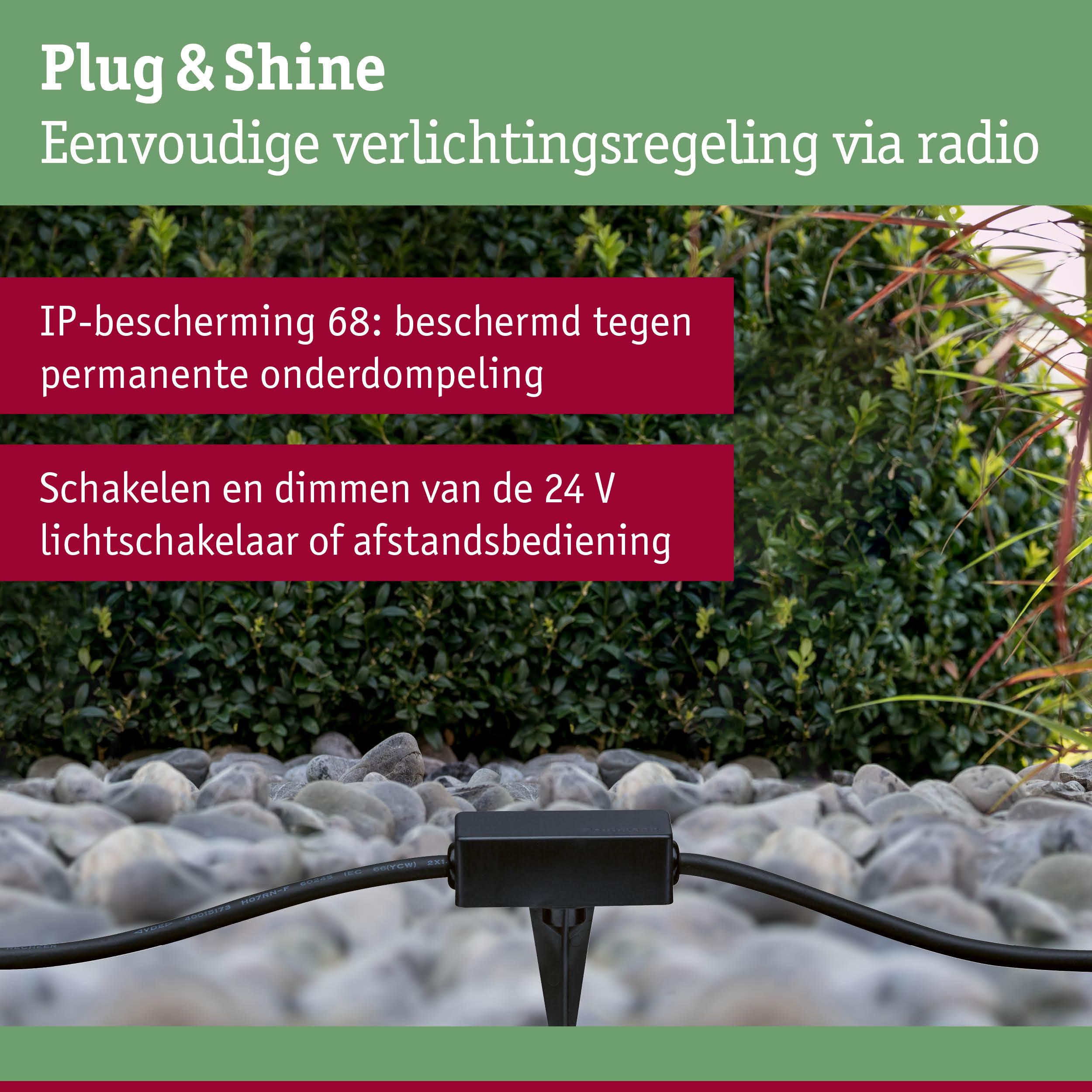 Zwart Plug & Shine besturingsapparaat op grind met groene achtergrond, IP68 bescherming voor buitenverlichting