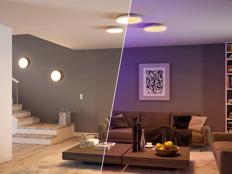 Modern living room with round ceiling and wall lights in warm white and colored light for atmospheric lighting.