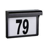Black plastic house number sign with large white panel and black digits 79 for outdoor lighting