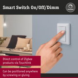 White smart dimmable switch on grey wall with finger pressing, Zigbee light control device