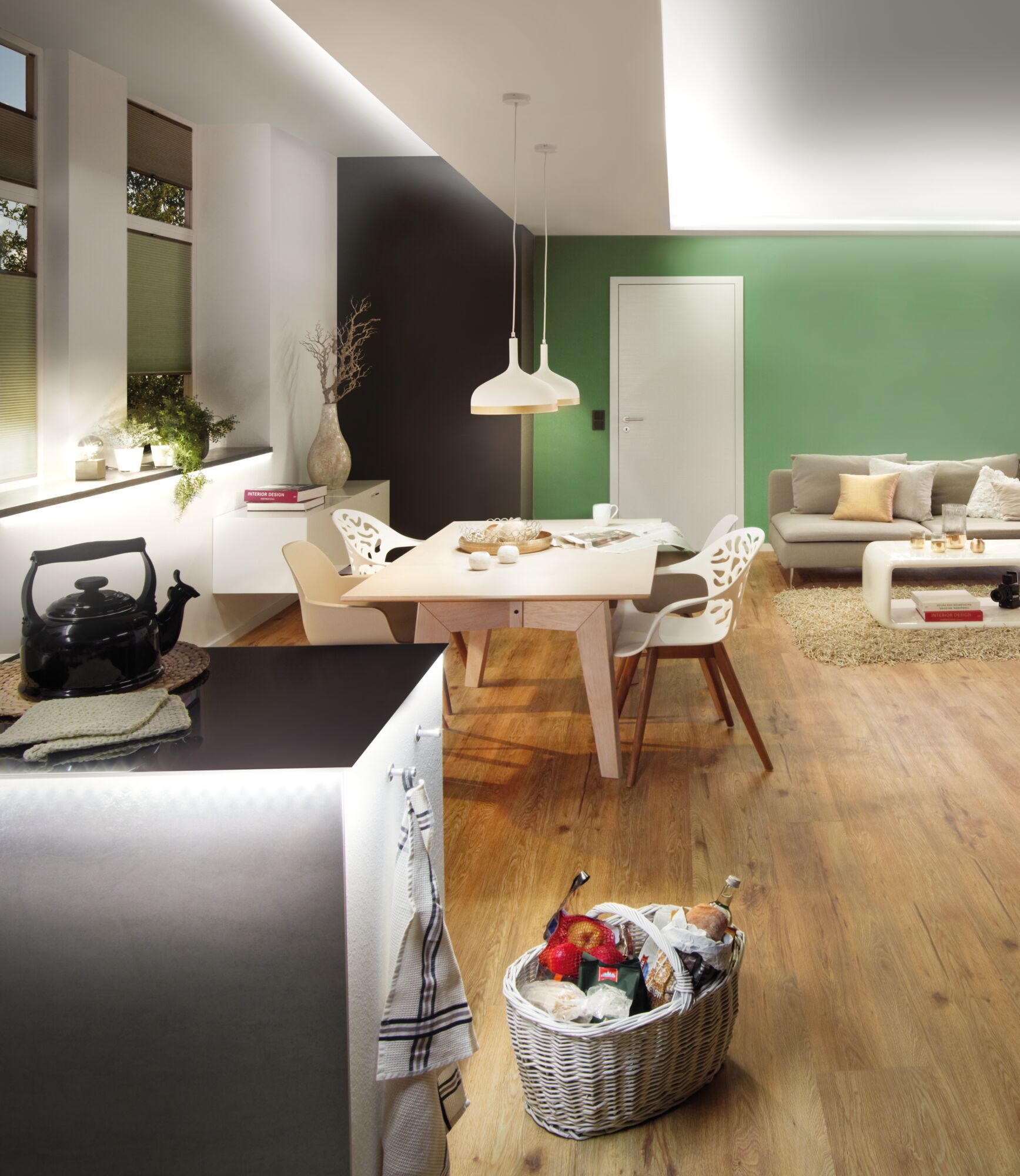Salon moderne avec mur vert, sol en bois et suspensions blanches pour éclairage d'ambiance