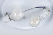 Close-up of two white E27 LED lamp holders with bulbs in a ceiling light fitting