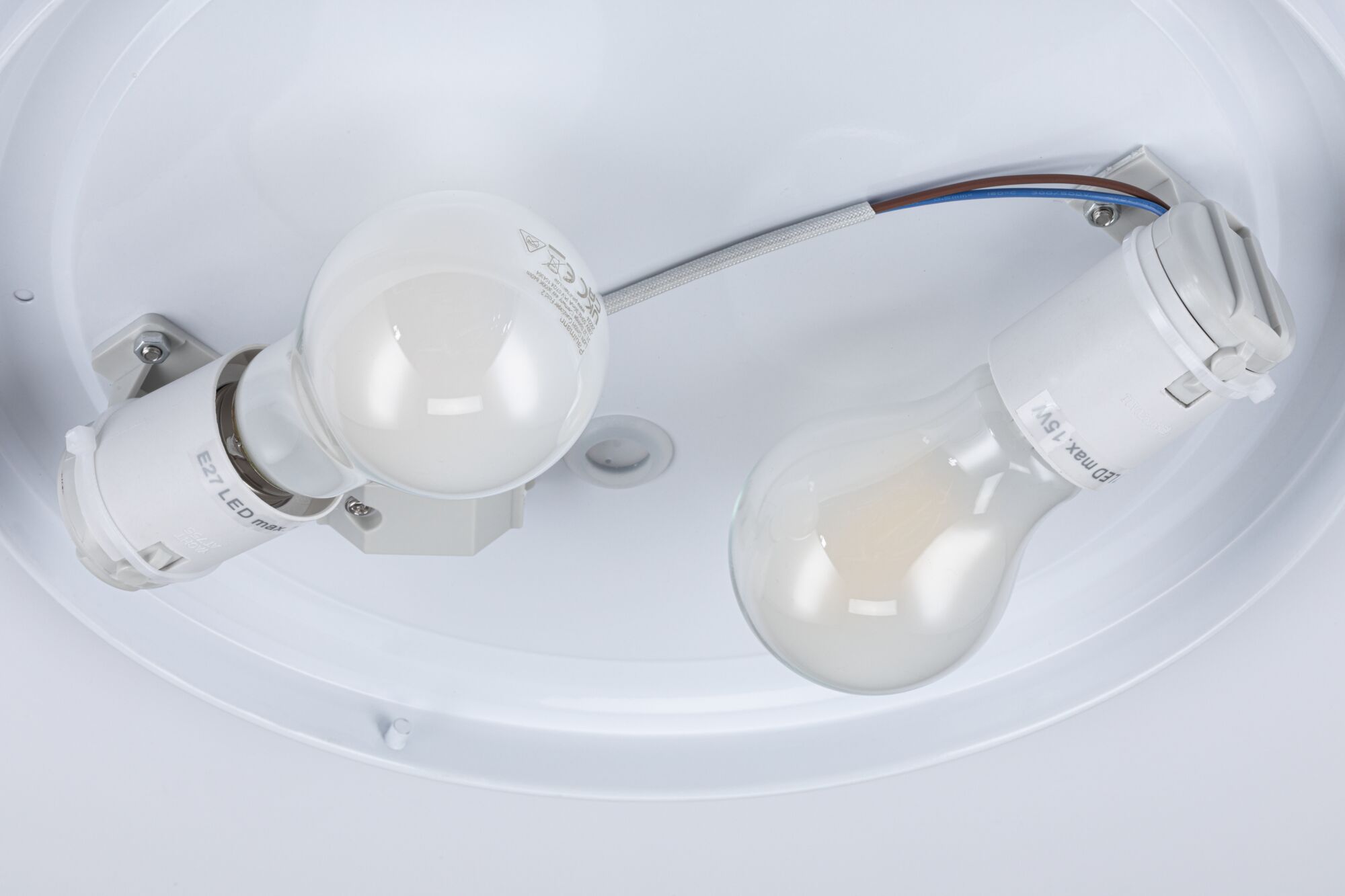 Close-up of two white E27 LED lamp holders with bulbs in a ceiling light fitting