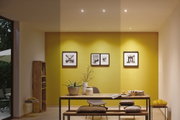 Modernes Esszimmer mit gelber Wand, Holz-Tisch, Bank, Stuhl und dekorativen Kissen für Wohnraumgestaltung