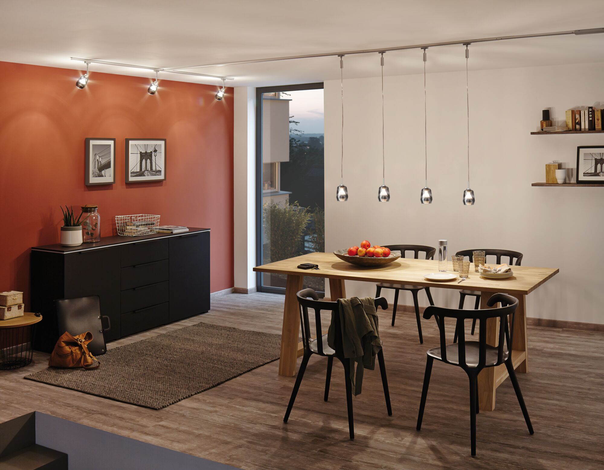 Modernes Esszimmer mit Holz-Tisch, schwarzen Stühlen und verstellbaren Deckenstrahlern für Akzentbeleuchtung.