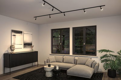 Modern living room with grey fabric sofa, black sideboard and black ceiling track lighting