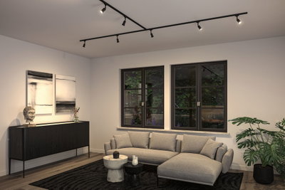 Modern living room with grey fabric sofa, black sideboard and black ceiling track lighting