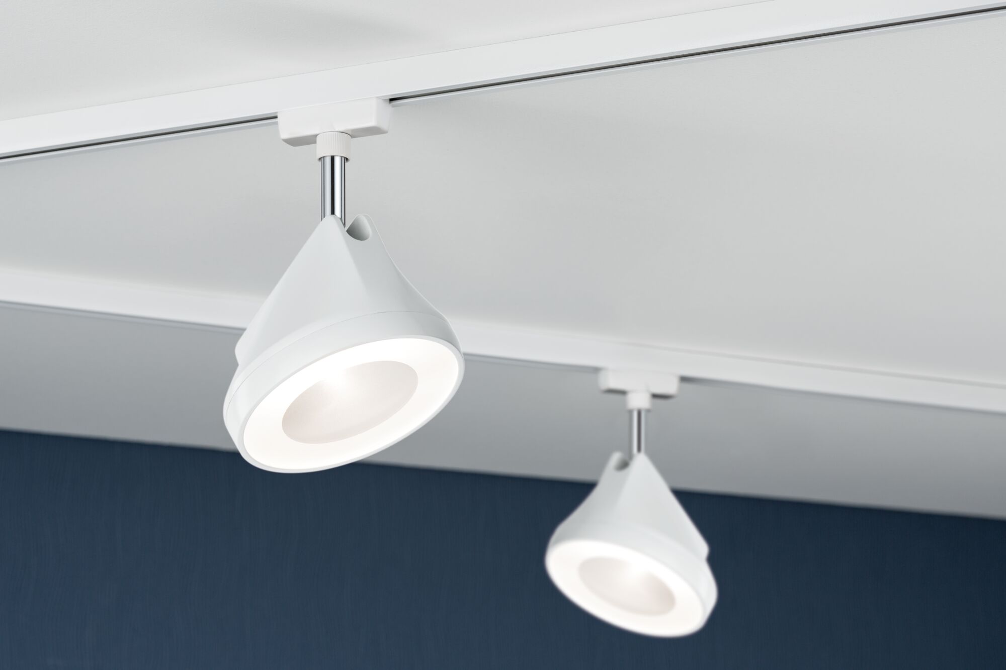 Two white LED ceiling spotlights in plastic on track system for modern room lighting