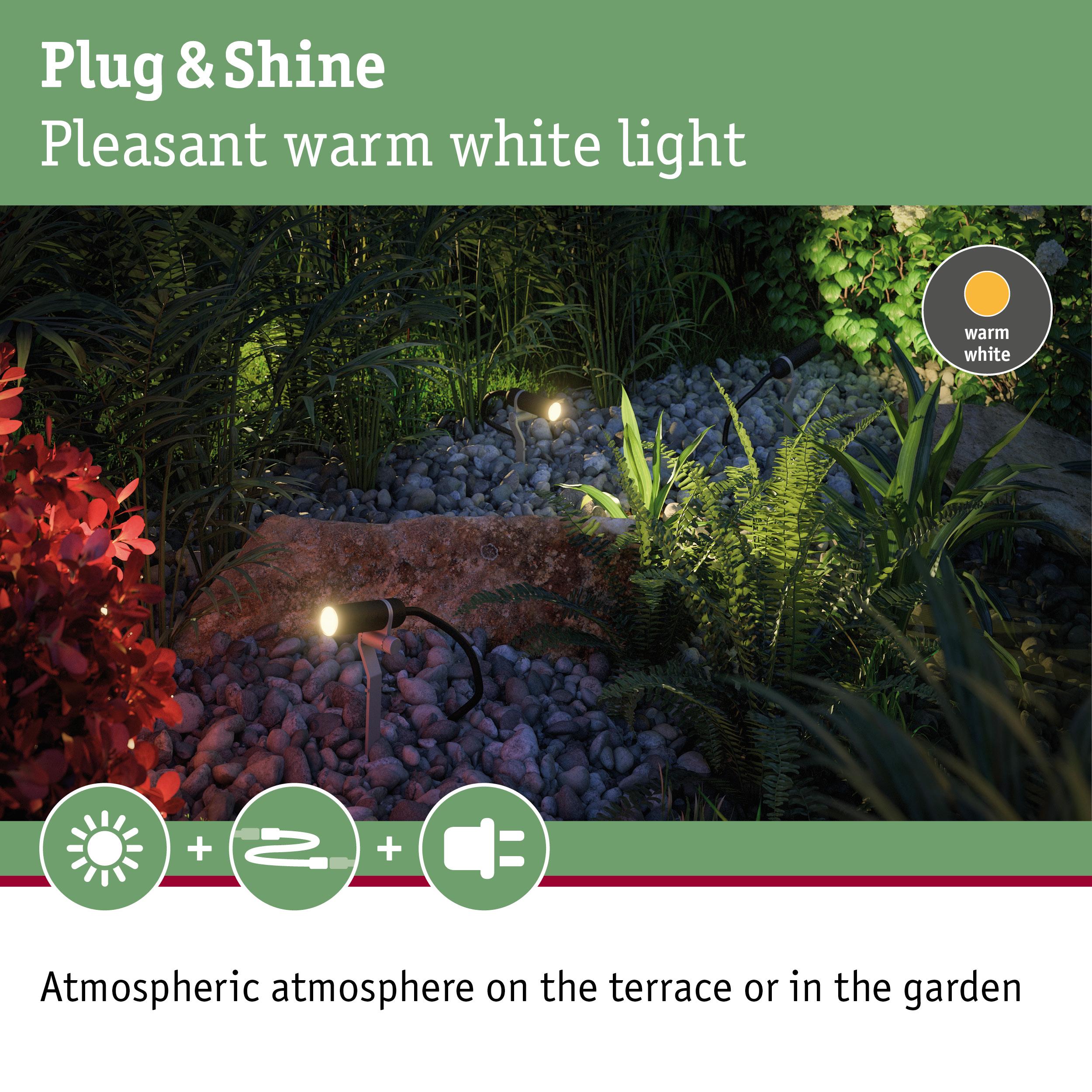Outdoor spotlights with warm white light on stones and plants for atmospheric garden lighting