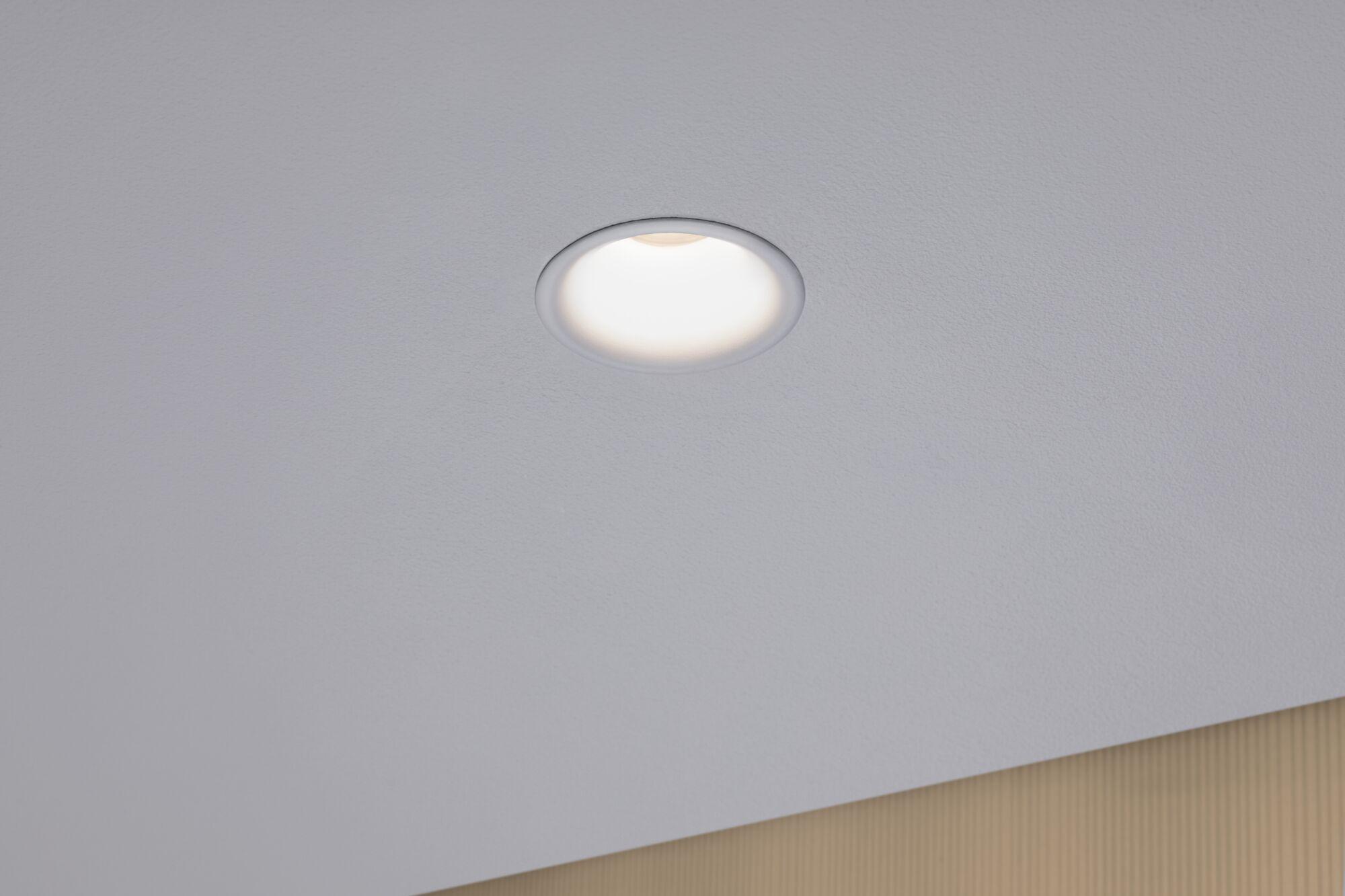 Round LED recessed light in white ceiling with warm white light for modern room illumination