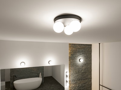 Moderne loftlampe med tre hvide glasglobuser og sort metalring i stilfuldt badeværelse med badekar