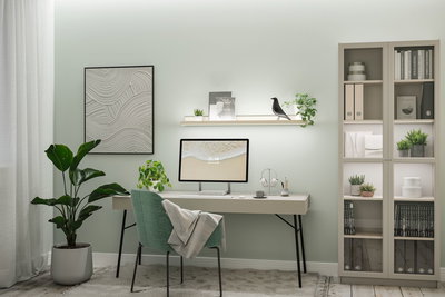 Modern home office with green fabric chair, light desk, and LED wall shelf lighting for workspace setup.