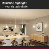 Moderne woonkamer met lichte houten eettafel, witte stoelen en minimalistische verlichting voor een gezellige sfeer