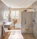 Modern bathroom with grey shower wall, wood-look floor, white sink, and LED ceiling light for bright lighting