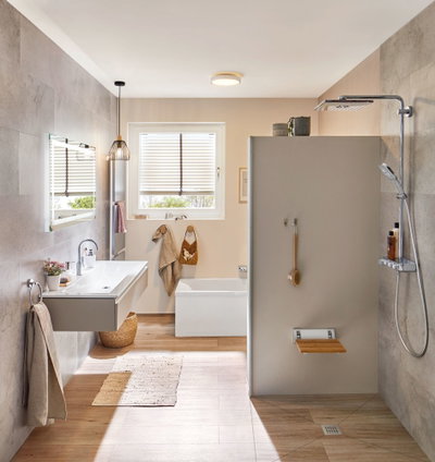 Modernes Badezimmer mit grauer Duschwand, Holzoptik Boden und weißem Waschbecken mit LED-Deckenleuchte