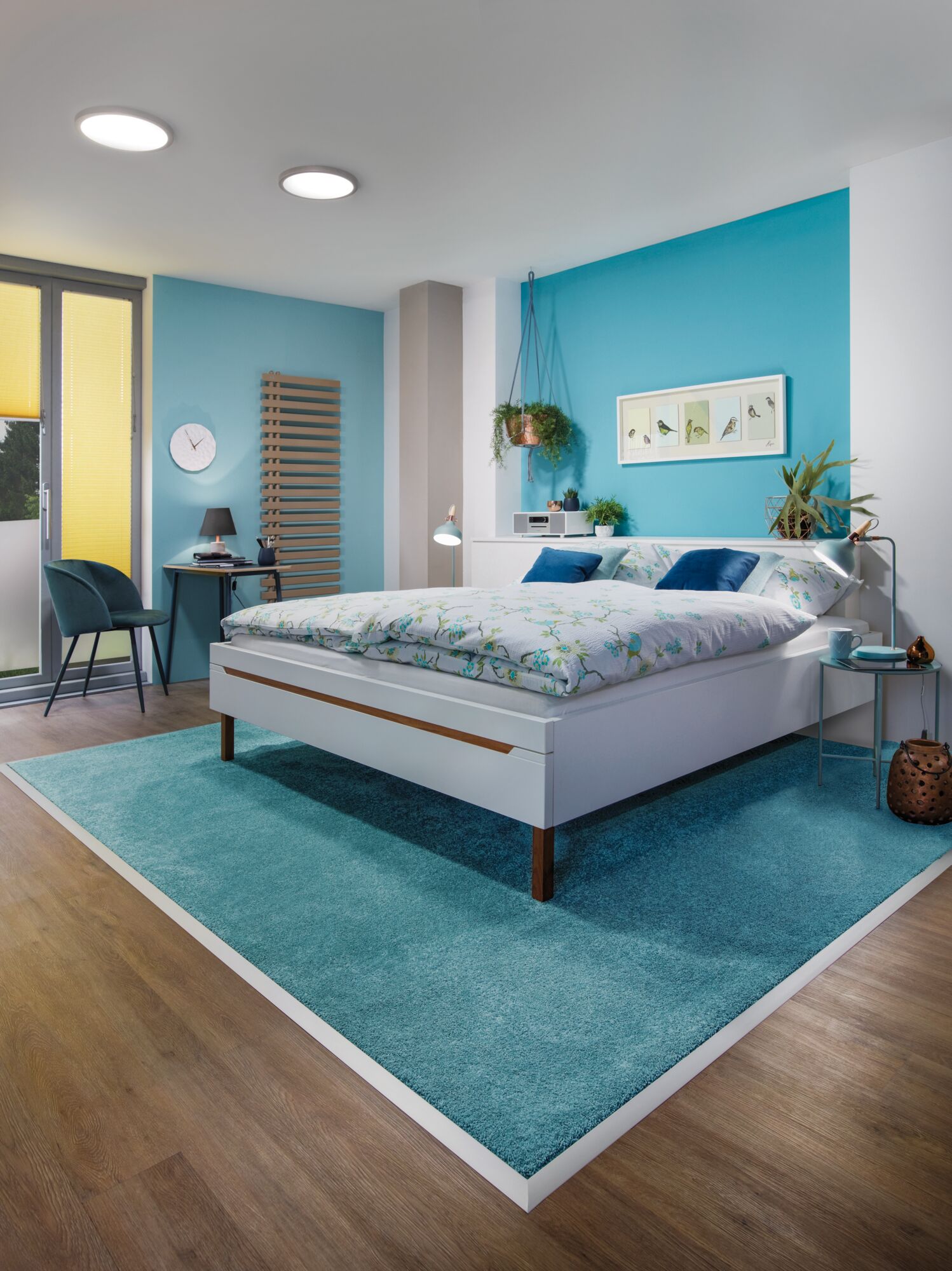 Moderne slaapkamer met wit bed, blauw vloerkleed en LED-plafondlampen voor sfeervolle verlichting