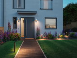 Modern house entrance with anthracite grey door and LED outdoor lighting along path and facade at dusk