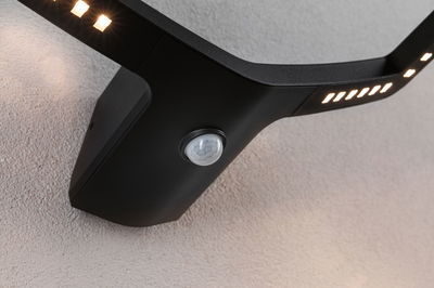 Zwarte LED-wandlamp met bewegingssensor en warm wit licht voor buitengebruik.