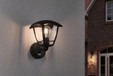 Black metal outdoor wall light with clear glass and visible bulb for house facade lighting