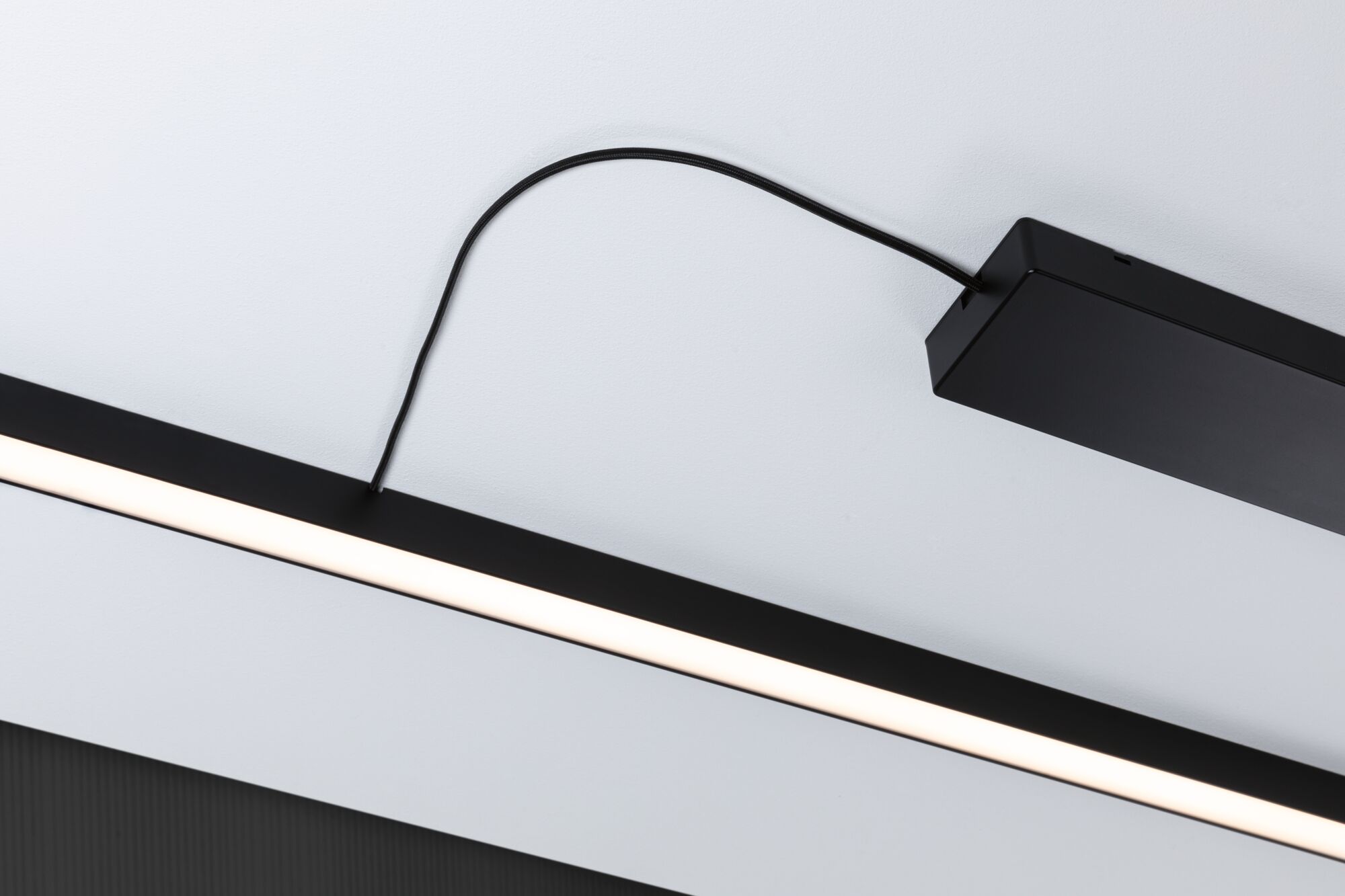 Zwarte LED-plafondlamp met slank, langwerpig ontwerp en warm wit licht voor moderne interieurs.