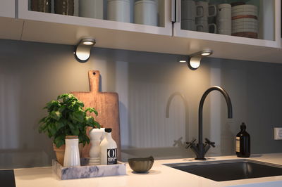 Moderne Küchenarbeitsplatte mit schwarzem Wasserhahn, Marmor-Tablett und warmweißer LED-Unterbauleuchte