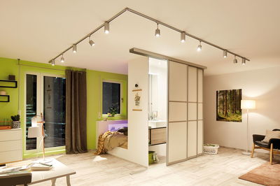 Moderne woonkamer met wit schuifdeursysteem en LED-plafondspots voor flexibele verlichting