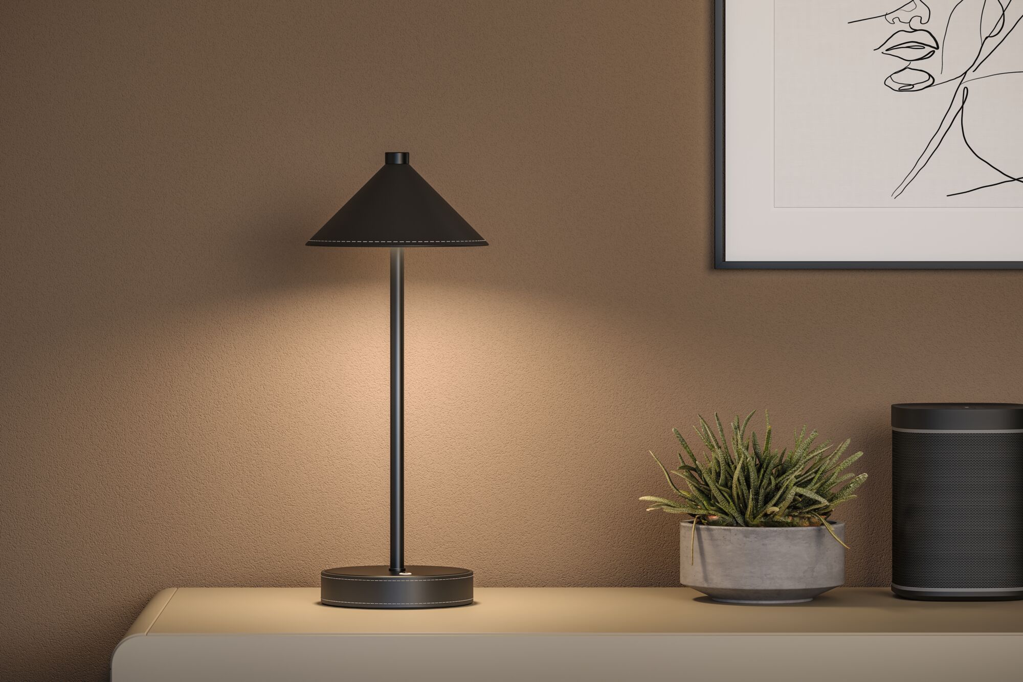 Schwarze Metall-Tischlampe mit konischem Schirm auf Sideboard neben Pflanze und Lautsprecher im Wohnzimmer