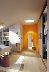 Modernes Schlafzimmer mit hellem Holzboden und quadratischer Deckenleuchte für warme Beleuchtung