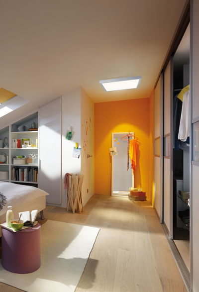 Modernes Schlafzimmer mit hellem Holzboden und quadratischer Deckenleuchte für warme Beleuchtung