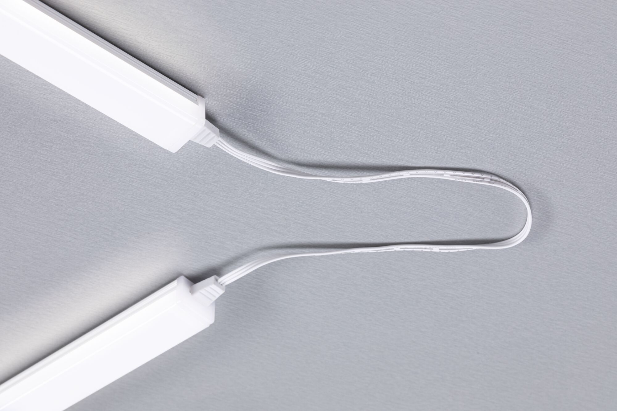 Zwei weiße LED-Leuchtleisten verbunden durch ein weißes Kabel auf grauem Hintergrund, LED-Beleuchtung Zubehör