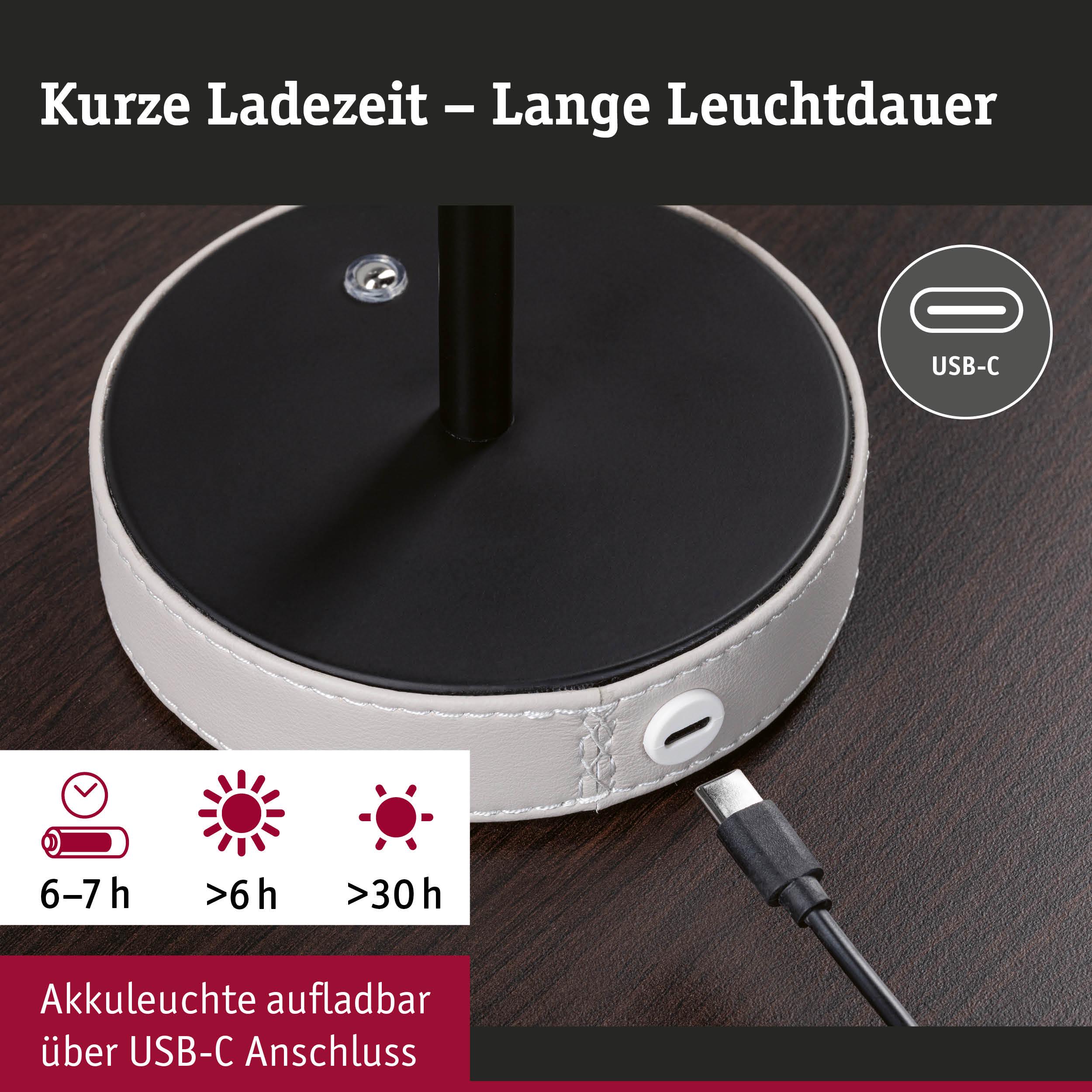 Ladebasis einer weißen Akkuleuchte mit USB-C Anschluss auf dunklem Holztisch, kurze Ladezeit und lange Leuchtdauer