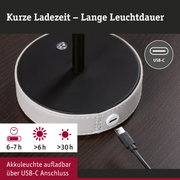 Ladegerät mit USB-C Anschluss und weißem Lederbezug auf dunklem Holztisch, Akku-Leuchte mit langer Leuchtdauer