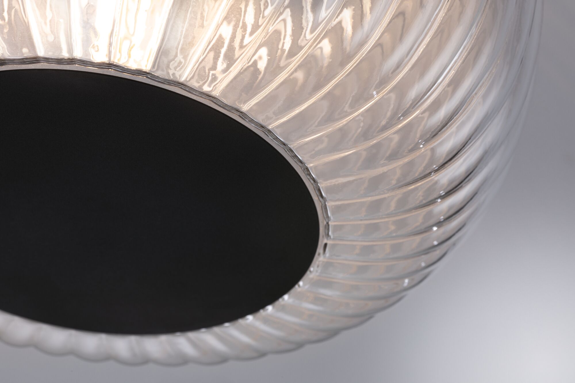 Close-up of transparent glass lamp with black center, modern lighting design for living spaces