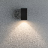 Applique murale LED rectangulaire noire en métal avec lumière blanche chaude sur mur texturé