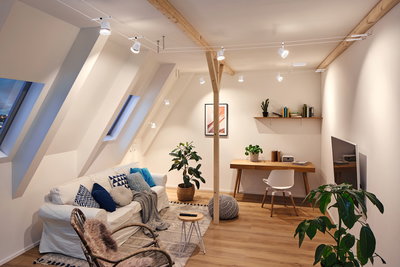 Modernes Wohnzimmer mit weißen Paulmann LED-Seilsystem-Strahlern und Holzdecke für warme Beleuchtung